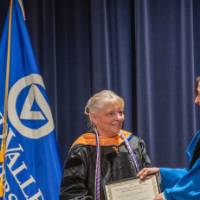 Provost Mili hands certificate to woman